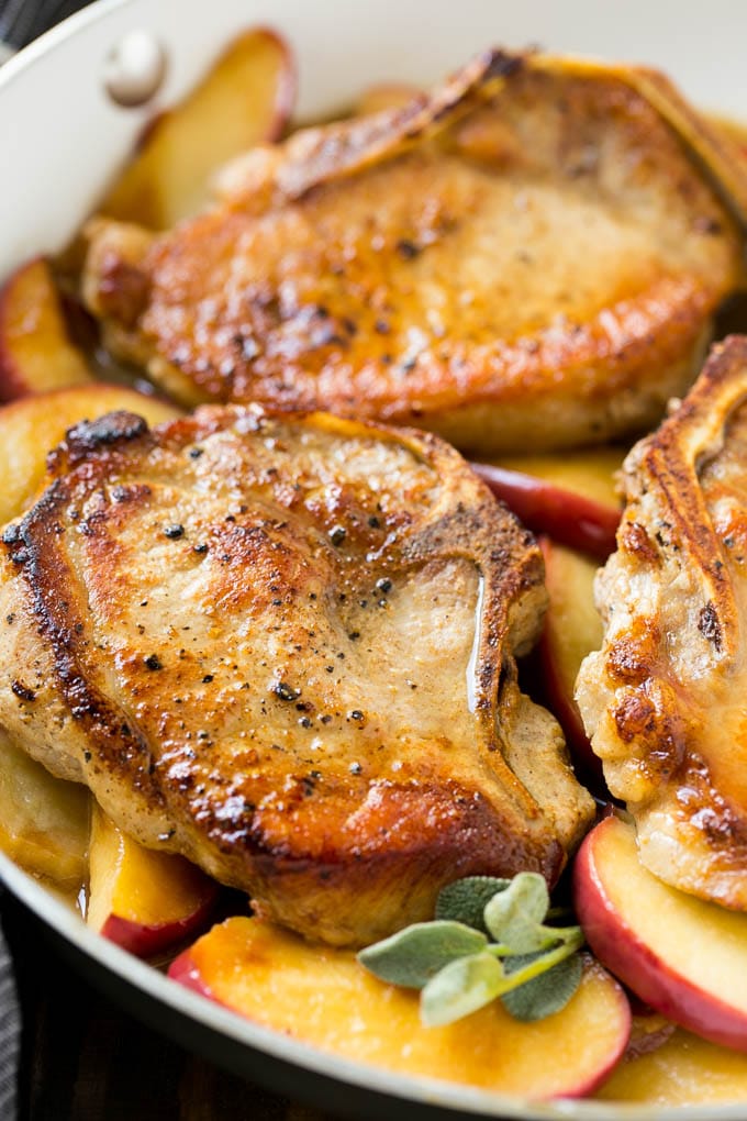 Seared pork in a pan in a sweet and savory sauce with fresh herbs.