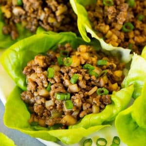 A plate full of beef lettuce wraps garnished with green onions.