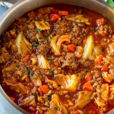 A pot full of cabbage roll soup garnished with parsley.