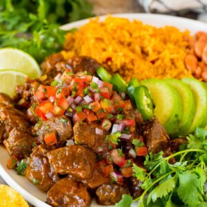 Carne guisada served with rice, beans and avocado.