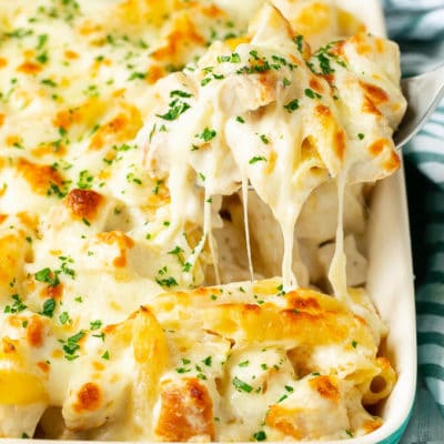 A spoon serving up a portion of chicken Alfredo bake.