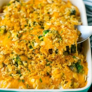 A spoon serving up a portion of chicken casserole made with rice and broccoli.