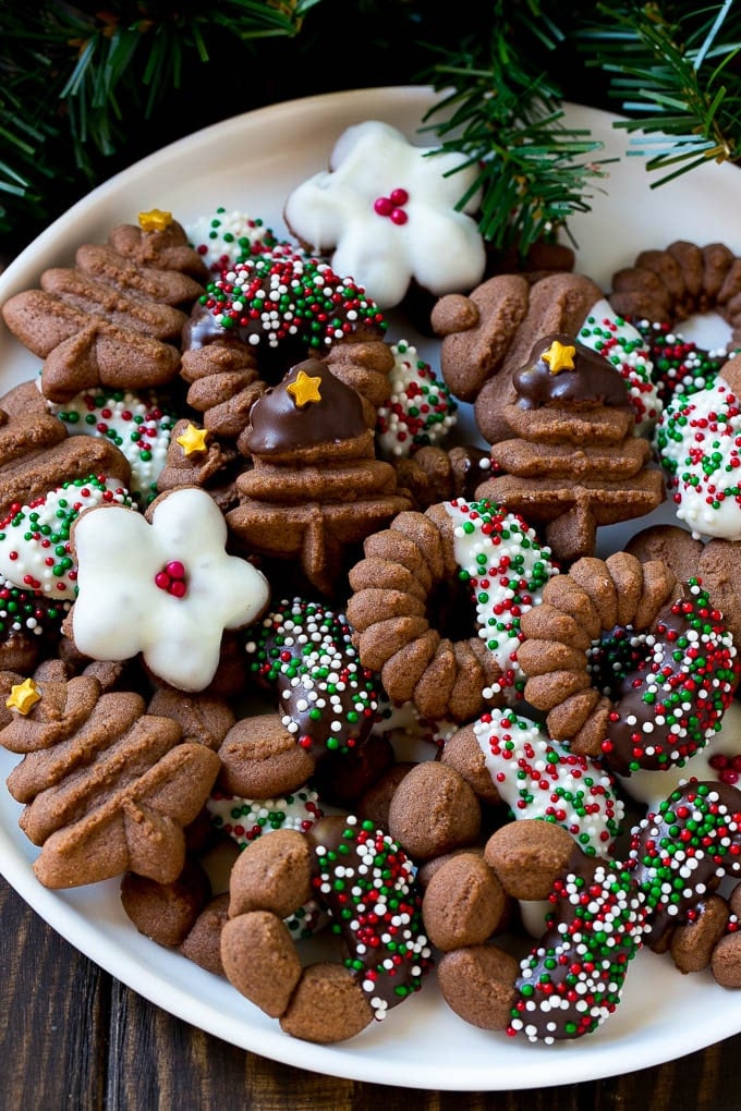 A plate of chocolate spritz cookies decorated with chocolate and sprinkles.