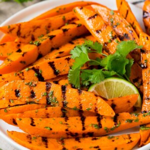 A plate of grilled sweet potatoes topped with cilantro lime dressing.