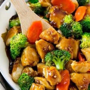 A pan of honey garlic chicken stir fry with a spatula in it.