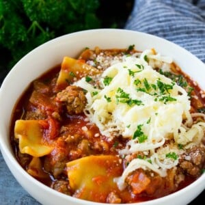 A bowl of lasagna soup topped with ricotta, parmesan and mozzarella cheeses.