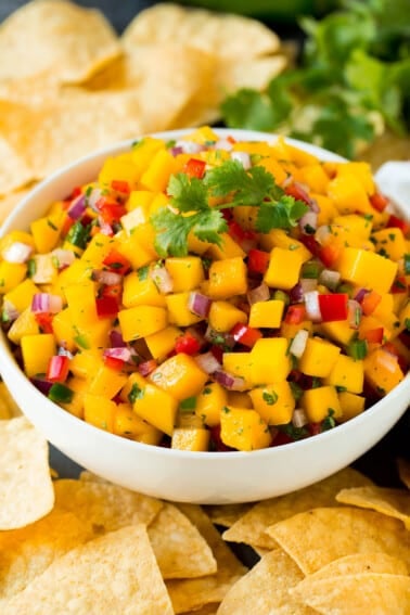 A bowl of mango salsa served with tortilla chips.