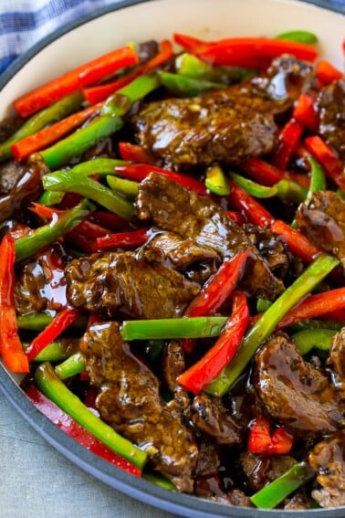 Pepper steak stir fry with thinly sliced steak and red and green bell peppers in a savory sauce.