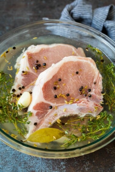 A bowl of pork chop brine with raw pork chops in it.