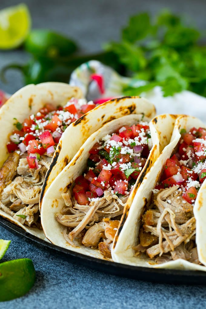 Pork tacos in flour tortillas topped with pico de gallo.