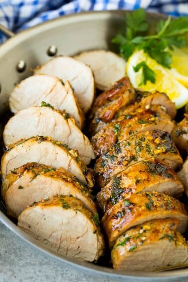 Pork tenderloin marinade with sliced cooked pork in a skillet.