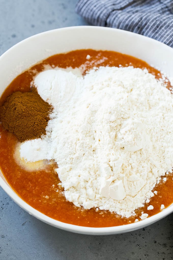 Flour, sugar, baking powder, pumpkin pie spice and other ingredients in a mixing bowl.