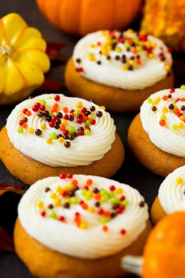 Pumpkin cookies topped with cream cheese frosting and fall sprinkles.