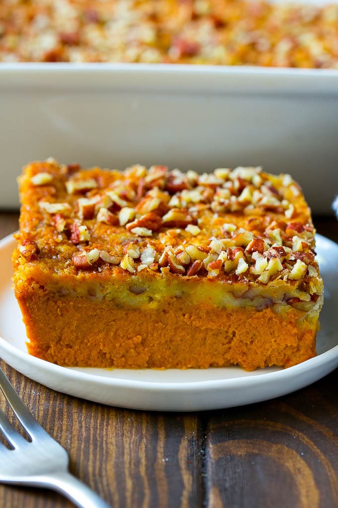 A slice of pumpkin dump cake topped with pecans.