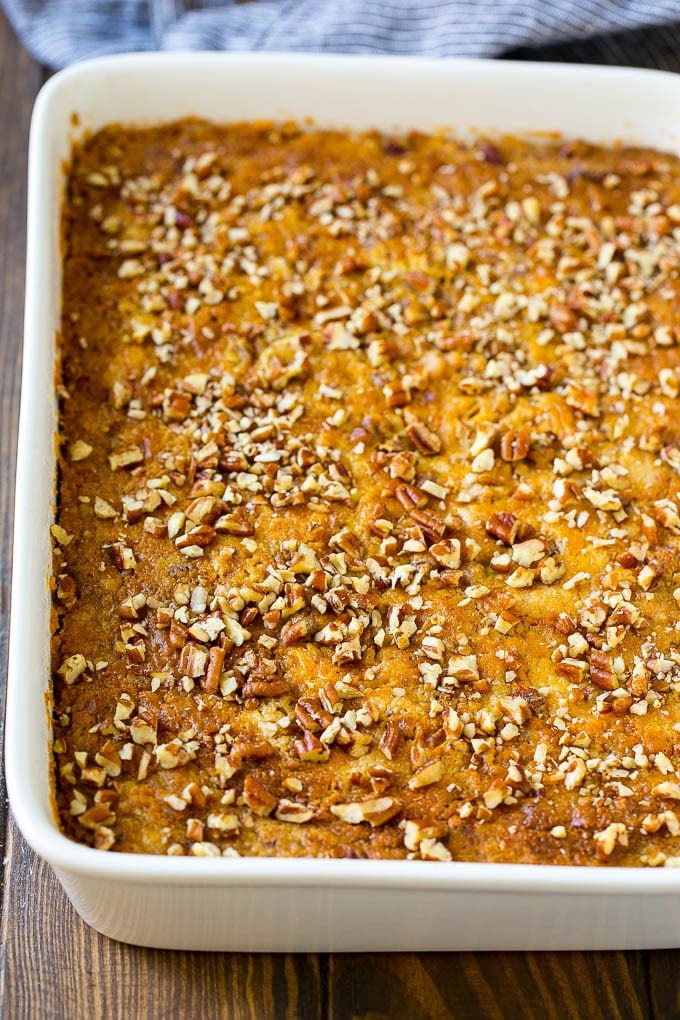 A pan of pumpkin dump cake topped with chopped pecans.