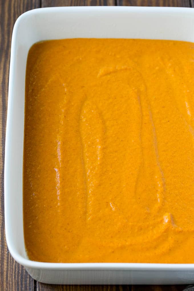 Pumpkin pie filling poured into a baking dish.