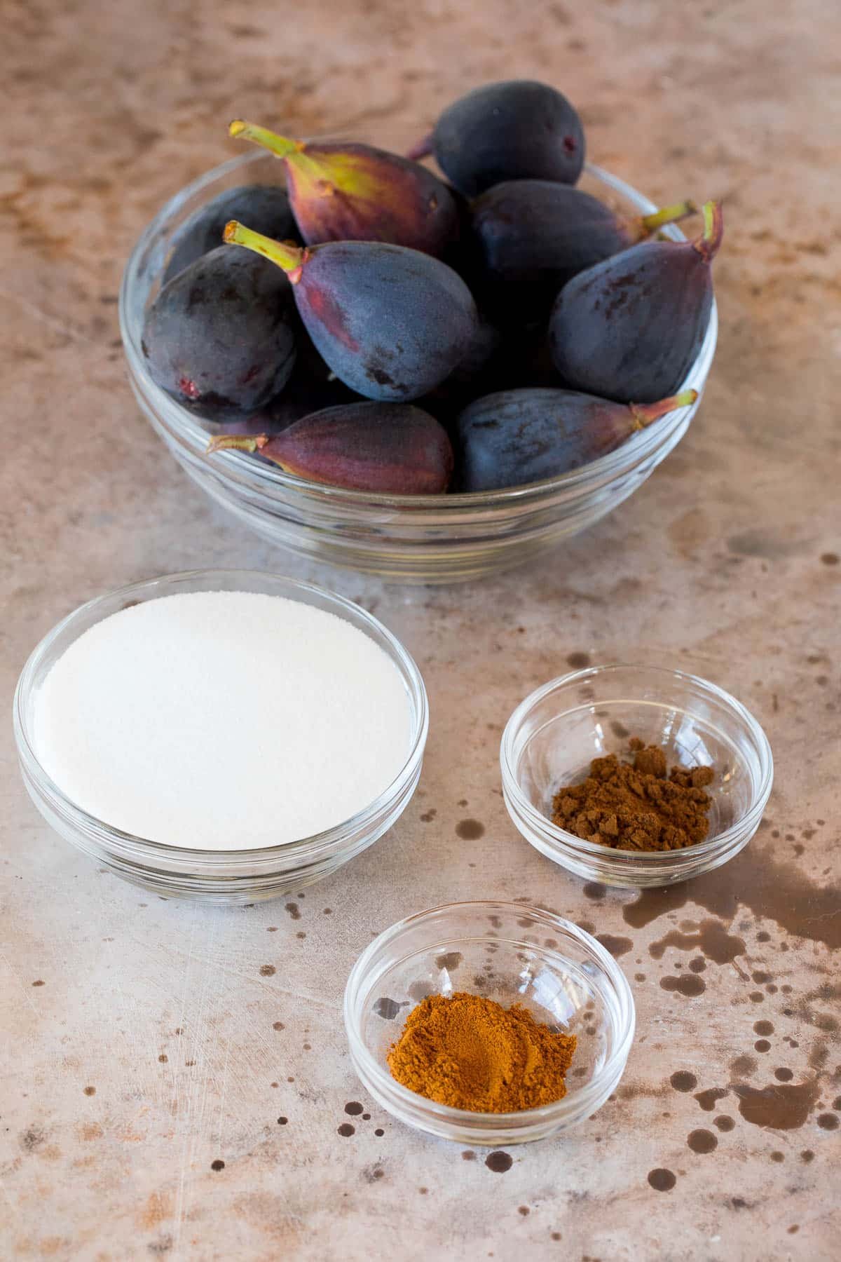 Figs, spices and sugar in bowls.