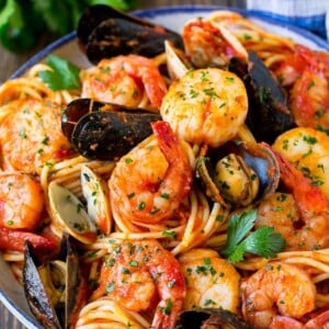 A bowl of seafood pasta with shrimp, clams and scallops.