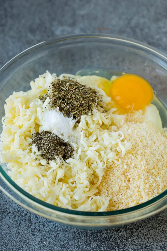 Ricotta cheese, parmesan, mozzarella, herbs and seasonings in a bowl.