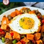 A plate of sweet potato hash with a sunny side up egg on top.